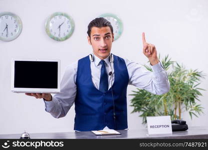 The young man receptionist at the hotel counter. Young man receptionist at the hotel counter