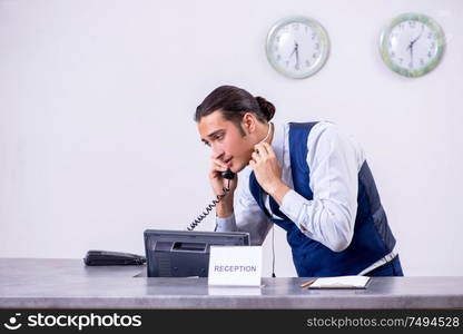 The young man receptionist at the hotel counter. Young man receptionist at the hotel counter