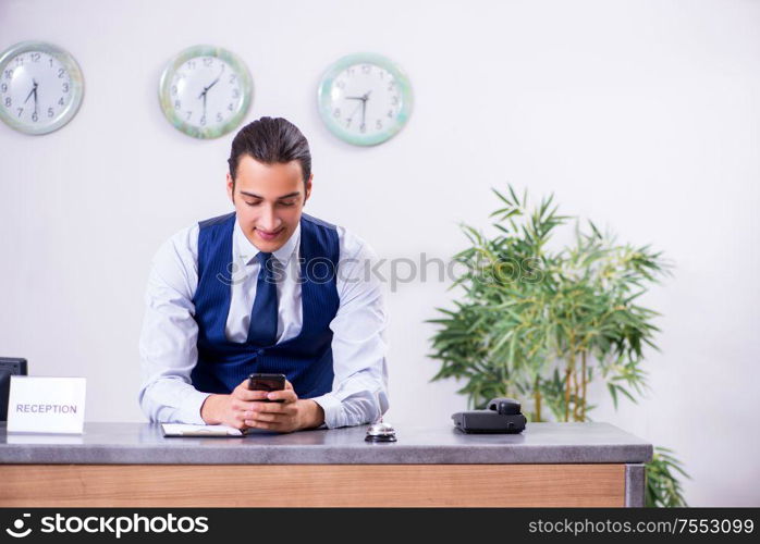 The young man receptionist at the hotel counter. Young man receptionist at the hotel counter