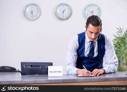 The young man receptionist at the hotel counter. Young man receptionist at the hotel counter