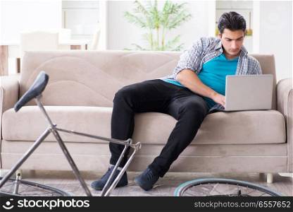 The young man repairing bicycle at home. Young man repairing bicycle at home