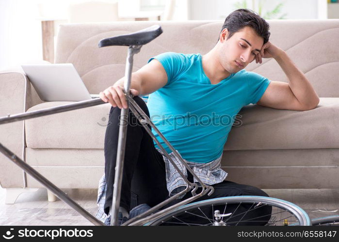 The young man repairing bicycle at home. Young man repairing bicycle at home