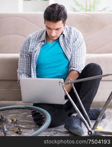 The young man repairing bicycle at home. Young man repairing bicycle at home