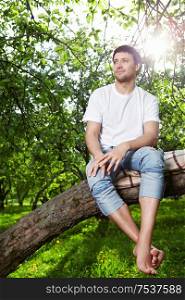 The young man sits on a tree