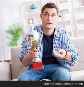 The young man student watching football at home. Young man student watching football at home