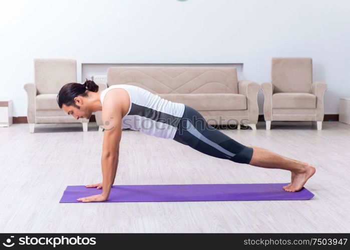 The young man training and exercising at home. Young man training and exercising at home