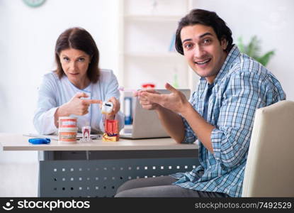 The young man visiting female doctor stomatologist. Young man visiting female doctor stomatologist