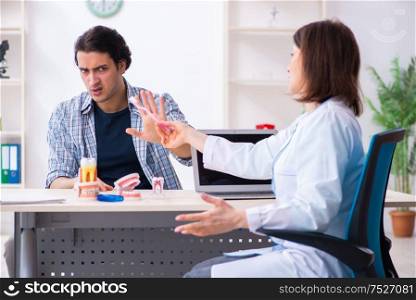 The young man visiting female doctor stomatologist. Young man visiting female doctor stomatologist