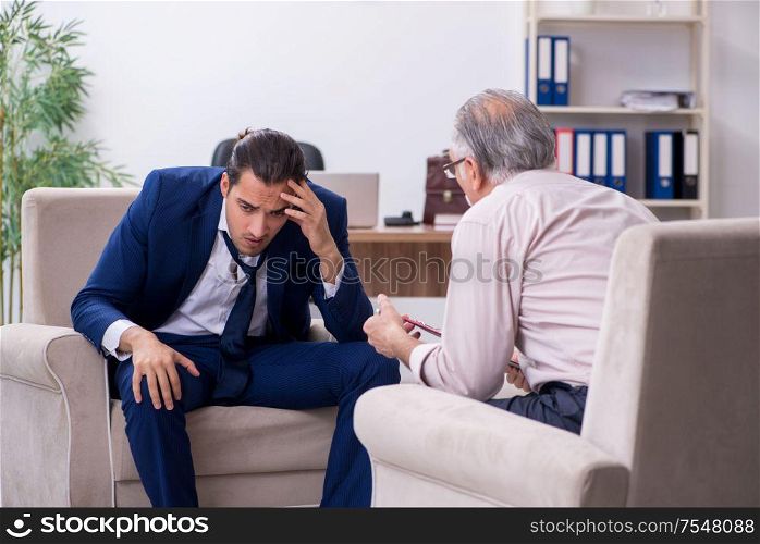 The young man visiting old male doctor psychologist. Young man visiting old male doctor psychologist
