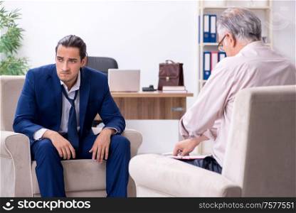 The young man visiting old male doctor psychologist. Young man visiting old male doctor psychologist