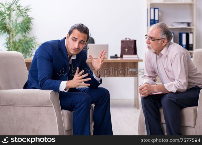 The young man visiting old male doctor psychologist. Young man visiting old male doctor psychologist