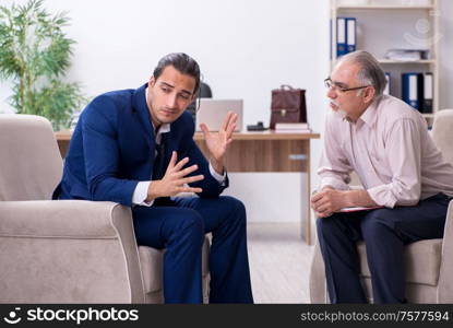 The young man visiting old male doctor psychologist. Young man visiting old male doctor psychologist