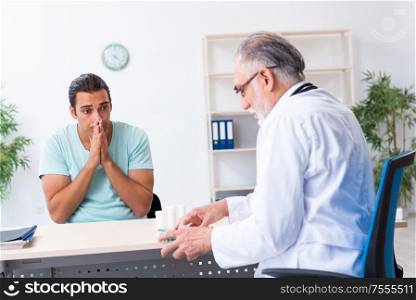 The young man visiting old male doctor. Young man visiting old male doctor