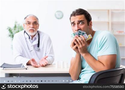 The young man visiting old male doctor. Young man visiting old male doctor