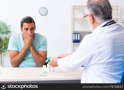 The young man visiting old male doctor. Young man visiting old male doctor