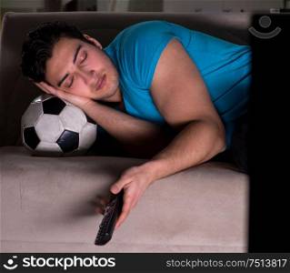 The young man watching football late at night. Young man watching football late at night