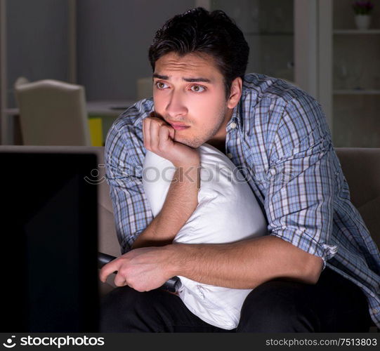 The young man watching tv late at night. Young man watching tv late at night