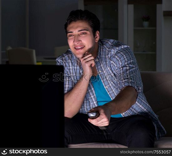 The young man watching tv late at night. Young man watching tv late at night