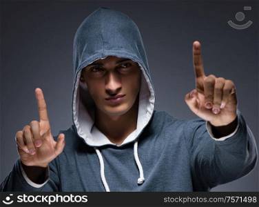 The young man wearing hoodie pressing virtual buttons. Young man wearing hoodie pressing virtual buttons