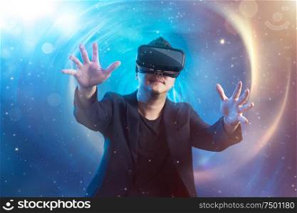 The young man wearing virtual reality goggles with amazing cosmic futuristic space virtual imaging background .