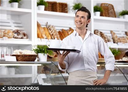 The young man with a tray on a forward background