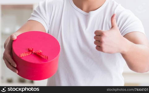 The young man with gift bag at home preparing suprise for wife. Young man with gift bag at home preparing suprise for wife