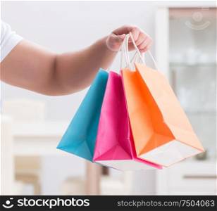 The young man with gift bag at home preparing suprise for wife. Young man with gift bag at home preparing suprise for wife