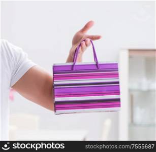 The young man with gift bag at home preparing suprise for wife. Young man with gift bag at home preparing suprise for wife