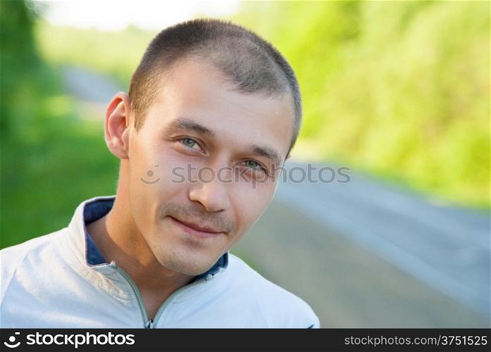 The young man with kind eyes on a summer background