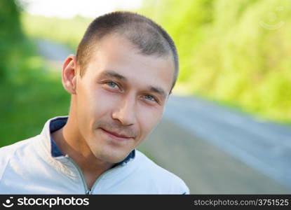 The young man with kind eyes on a summer background