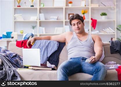 The young man working studying in messy room. Young man working studying in messy room