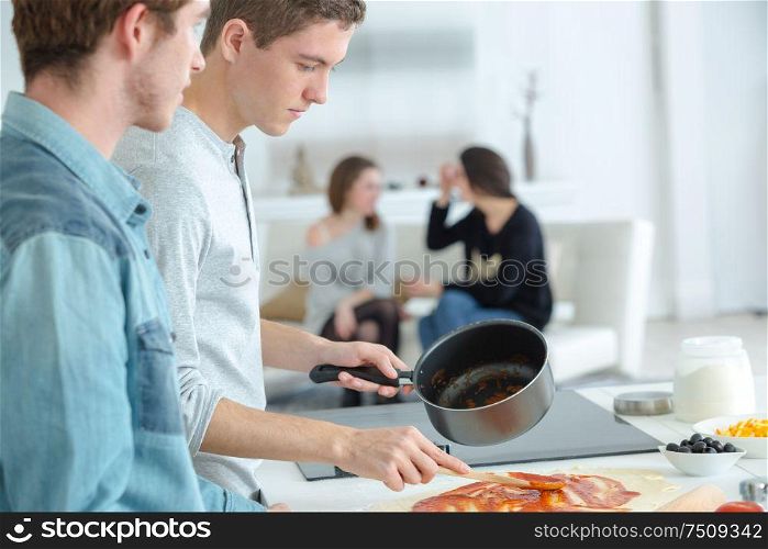 the young men cooking together