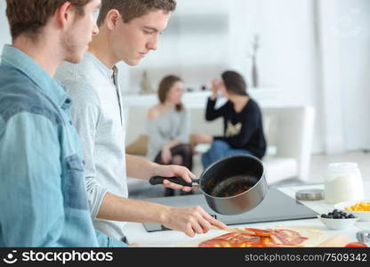 the young men cooking together