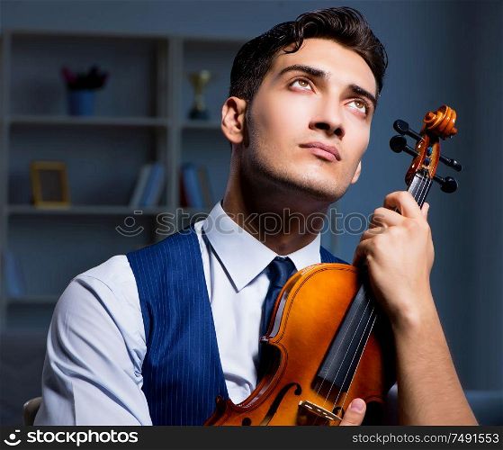 The young musician man practicing playing violin at home. Young musician man practicing playing violin at home
