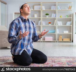 The young muslim man praying at home. Young muslim man praying at home