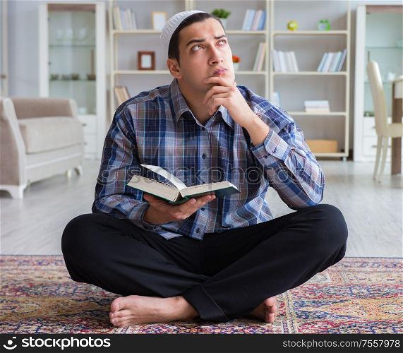 The young muslim man praying at home. Young muslim man praying at home