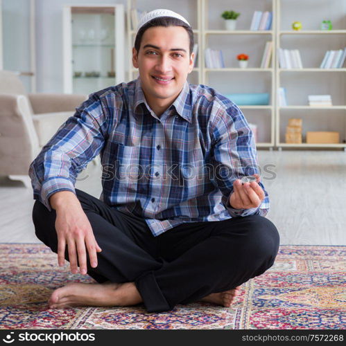 The young muslim man praying at home. Young muslim man praying at home