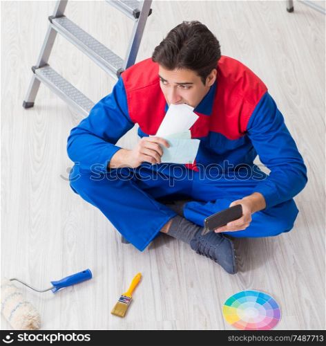 The young painter trying to match colours for painting job. Young painter trying to match colours for painting job