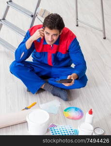 The young painter trying to match colours for painting job. Young painter trying to match colours for painting job