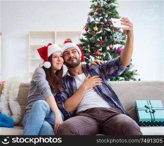 The young pair taking selfies during christmas. Young pair taking selfies during christmas