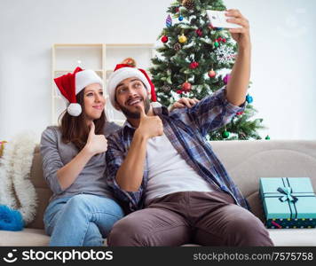 The young pair taking selfies during christmas. Young pair taking selfies during christmas