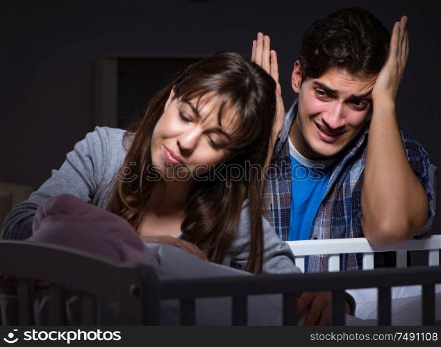 The young parents sleepless with newborn baby at night. Young parents sleepless with newborn baby at night