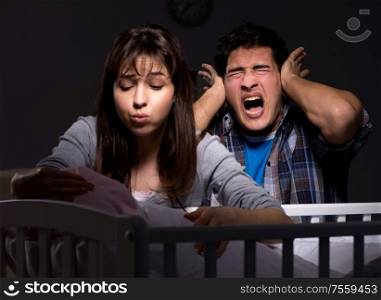 The young parents sleepless with newborn baby at night. Young parents sleepless with newborn baby at night
