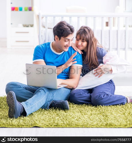 The young parents with their newborn baby sitting on the carpet. Young parents with their newborn baby sitting on the carpet