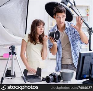 The young photographer working in photo studio. Young photographer working in photo studio