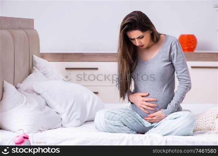 The young pregnant woman in the bedroom . Young pregnant woman in the bedroom 