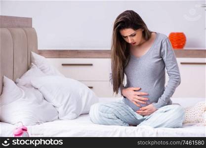 The young pregnant woman in the bedroom . Young pregnant woman in the bedroom 