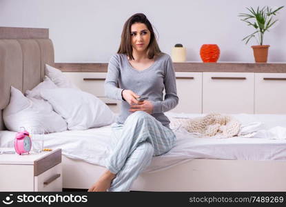 The young pregnant woman in the bedroom . Young pregnant woman in the bedroom