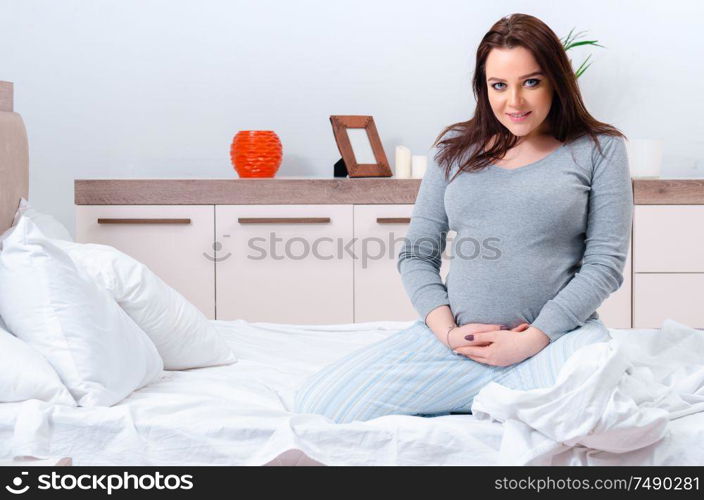 The young pregnant woman in the bedroom. Young pregnant woman in the bedroom