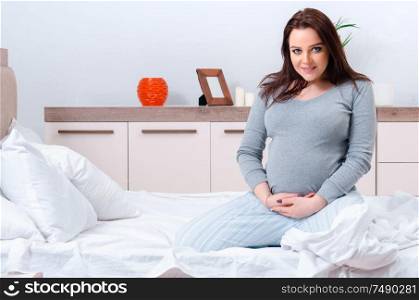 The young pregnant woman in the bedroom. Young pregnant woman in the bedroom